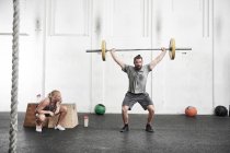 Homme levant haltère dans la salle de gym — Photo de stock