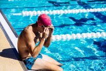 Swimmer sitting at end of pool — Stock Photo