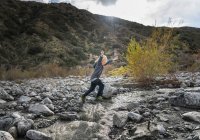 Boy leaping over rocks — Stock Photo