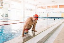 Senior klettert aus Schwimmbad — Stockfoto