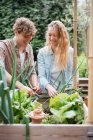 Man and woman tending to plants — Stock Photo