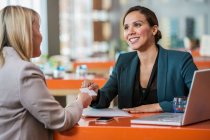 Businesswomen making introductions in cafe — Stock Photo