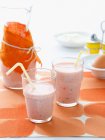 Copos com smoothie de morango e tubos de beber — Fotografia de Stock