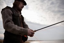Homem usando haste de pesca — Fotografia de Stock