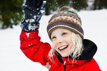 Souriante fille jouer dans la neige — Photo de stock
