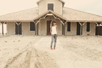 Donna in piedi di fronte all'edificio abbandonato — Foto stock
