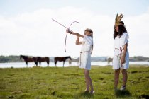 Meninas em trajes com arco e flechas — Fotografia de Stock