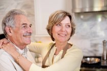 Smiling mature couple in kitchen — Stock Photo