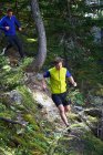 Due uomini che corrono nella foresta — Foto stock