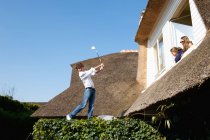 Boy play golf on roof — Stock Photo