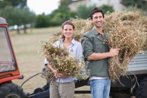 Man and woman posing with hay in hands — Stock Photo