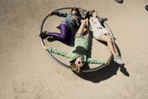 Жінки лежать в колі на дитячому майданчику — стокове фото
