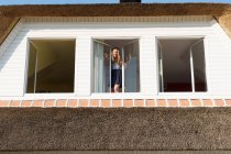 Menina de pé na janela aberta — Fotografia de Stock