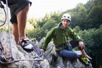 Bergsteiger sitzt auf Felsen — Stockfoto