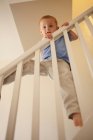 Boy climbing banister of steps — Stock Photo