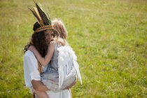 Girls in costumes hugging outdoors — Stock Photo