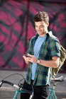 Young man on bicycle reading text — Stock Photo