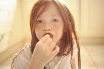 Porträt eines Mädchens, das Erdbeere isst — Stockfoto