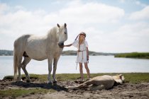 Девушка ласкает лошадь на пляже — стоковое фото