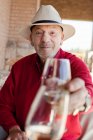 Старший человек звенящий бокал вина — стоковое фото