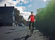 Woman cycling on city street — Stock Photo