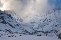 Caminhante na paisagem montanhosa nevada — Fotografia de Stock