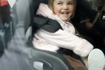 Laughing girl sitting in car seat — Stock Photo