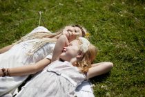 Девушки в костюмах, лежащие в траве — стоковое фото