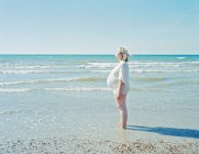 Pregnant woman standing on beach — Stock Photo