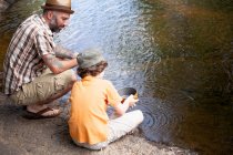 Father and son panning for gold — Stock Photo