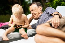Older man relaxing with grandson — Stock Photo