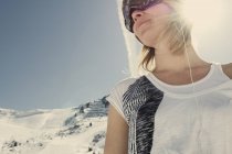 Mujer en camiseta admirando las colinas nevadas - foto de stock