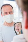 Dentista mostrando paciente seus dentes — Fotografia de Stock