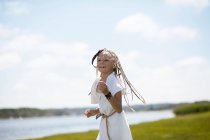 Chica en traje corriendo en la orilla cubierta de hierba - foto de stock