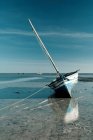 Barca ormeggiata in acque poco profonde — Foto stock