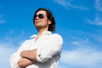 Young man in front of blue sky — Stock Photo