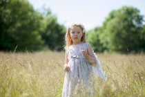Menina vestindo asas de anjo no campo — Fotografia de Stock