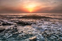 Вода, смывающая камни на пляже — стоковое фото