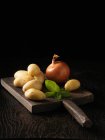 Board of potatoes and onions — Stock Photo