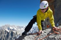 Montañista alcanzando cumbre - foto de stock