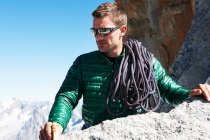Mountaineer with climbing rope over shoulder — Stock Photo