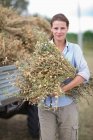 Agricoltore posa con una manciata di coltura secca — Foto stock