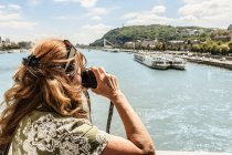 Woman taking pictures of river — Stock Photo