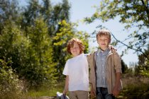 Smiling boys hugging outdoors — Stock Photo