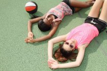 Жінки лежать на баскетбольному майданчику — стокове фото