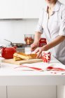 Mulher cortando sanduíches na cozinha — Fotografia de Stock