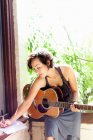 Frau schreibt Musik mit Gitarre — Stockfoto
