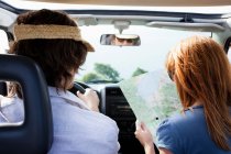 Ehepaar im Auto schaut auf Karte — Stockfoto
