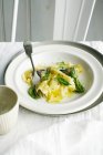 Plate of ravioli and herbs — Stock Photo