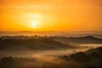 Nascer do sol sobre a paisagem rural nebulosa — Fotografia de Stock